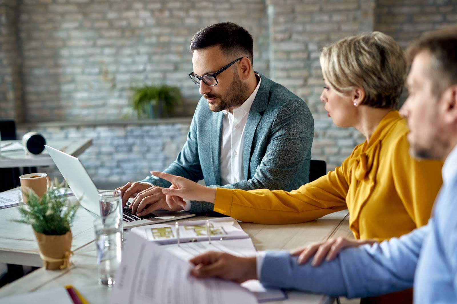 Financial advisor working on a computer while having a meeting with a couple